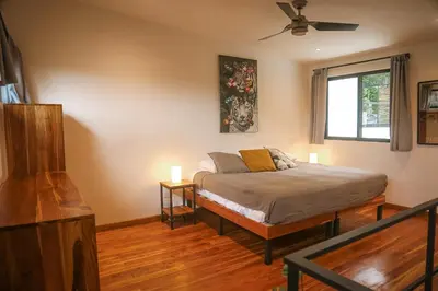 a bedroom with a bed and a window at El Hábita CASA SELVA in Santa Teresa Beach