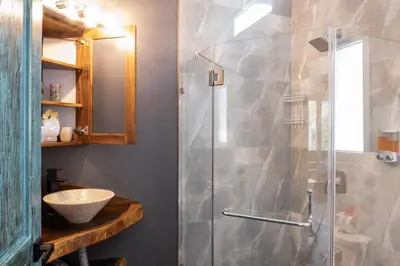a bathroom with a glass shower with a sink at Hotel FAREMITI Uvita in Uvita