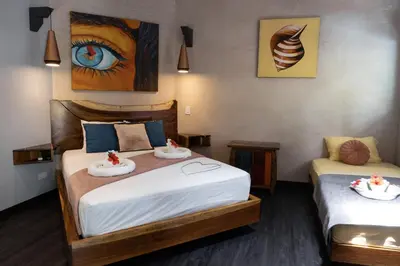 a bedroom with two beds with towels on them at Hotel FAREMITI Uvita in Uvita