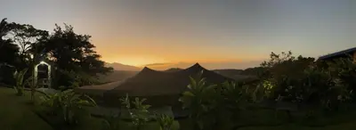 a sunset in the distance with tents in a yard at Casa maar -Treetop tent in Río Cuarto