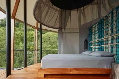 a bedroom with a bed and a large window at Art Villas Costa Rica, Villas & Glamping in Uvita