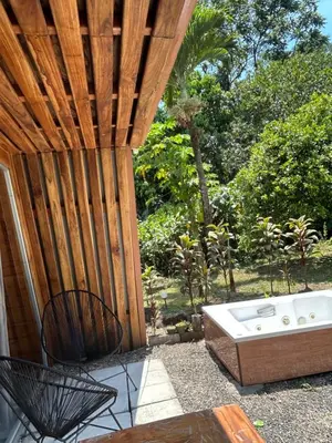 a patio with a jacuzzi tub sitting next to a fence at Tiny Villa Experience in Fortuna