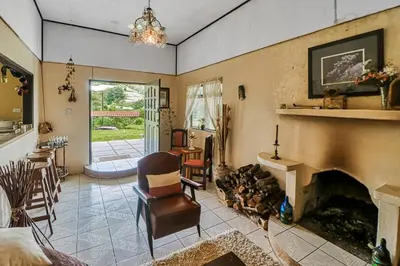 a living room with a fireplace and a chair at Casita El Sastre in Paso Macho