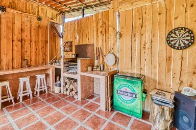 a kitchen with a stove and a dartboard in a cabin at Casita El Sastre in Paso Macho