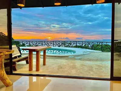 a room with a table and a view of the ocean at Akua Suites Ocean View in Tarcoles