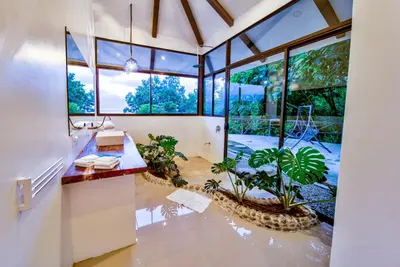 a bathroom with a sink and a large window at Akua Suites Ocean View in Tarcoles