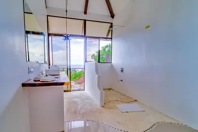 a hallway with white walls and glass windows at Akua Suites Ocean View in Tarcoles
