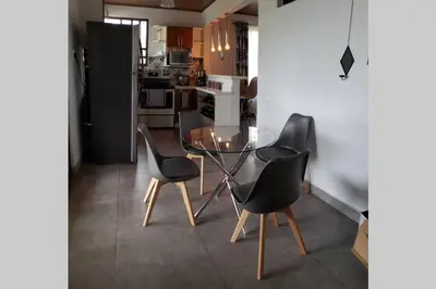 a kitchen with a glass table and four chairs at Villa Tropical La Fortuna in Fortuna