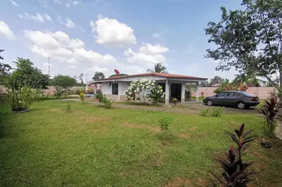a house with a car parked in a yard at Villa Tropical La Fortuna in Fortuna