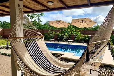 a hammock in front of a swimming pool at Villa Tropical La Fortuna in Fortuna