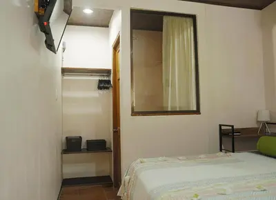 a bedroom with a bed and a mirror on the wall at Apartamentos y Studios Brisas del Mar Santa Teresa in Santa Teresa Beach