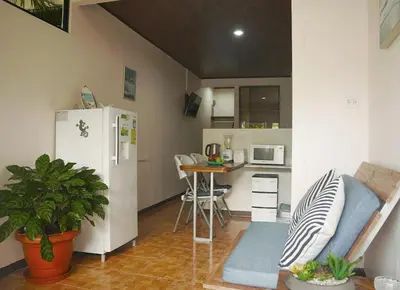 a small kitchen with a white refrigerator and a table at Apartamentos y Studios Brisas del Mar Santa Teresa in Santa Teresa Beach