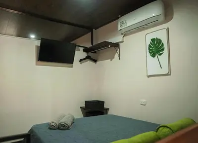 a bedroom with a bed with a tv and a bed sidx sidx sidx at Apartamentos y Studios Brisas del Mar Santa Teresa in Santa Teresa Beach