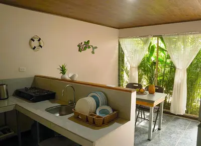 a kitchen with a sink and a table and a window at Apartamentos y Studios Brisas del Mar Santa Teresa in Santa Teresa Beach