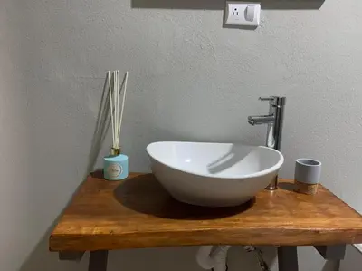 a white bowl sink on a wooden counter in a bathroom at Casita Anastacia in Uvita