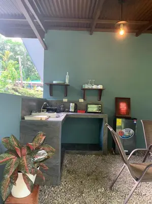 a kitchen with a sink and a table and chairs at Casita Anastacia in Uvita