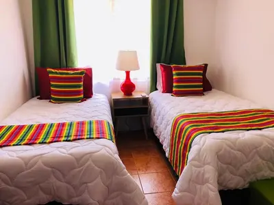 a bedroom with two beds with colorful pillows and a lamp at Valle Dorado 9 in Coco