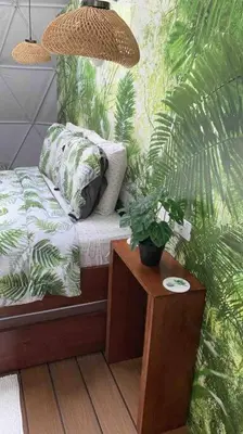 a bedroom with a bed and a table with a plant at Ubuntu Glamping in Guanacaste