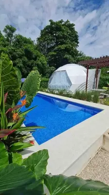 a blue swimming pool with a domedificialificialificialificialificialificialificialificial at Ubuntu Glamping in Guanacaste