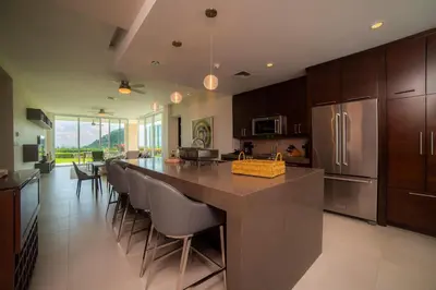 a kitchen with a large island with a bar with chairs at Montecielo 3E 3bdrs ocean view in Los Suenos in Herradura
