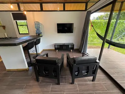 a living room with a bar and a table and chairs at Pacheco Tours Rainforest Cabins 4x4 Only in Drake
