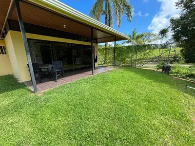 a house with a patio and a grass yard at Pacheco Tours Rainforest Cabins 4x4 Only in Drake