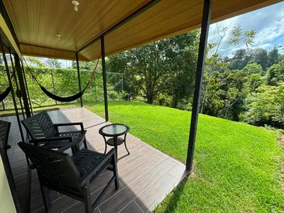 a screened in porch with chairs and a hammock at Pacheco Tours Rainforest Cabins 4x4 Only in Drake