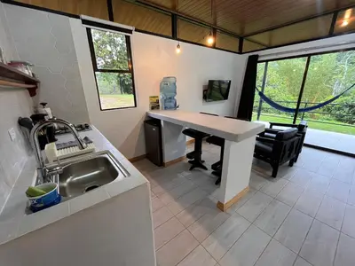a kitchen with a sink and a table in a room at Pacheco Tours Rainforest Cabins 4x4 Only in Drake