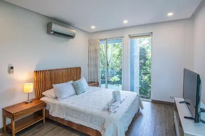 a bedroom with a bed and a flat screen tv at Luxury Villa #10 De Las Mariposas in Playa Hermosa