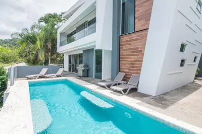 a house with a swimming pool next to a house at Luxury Villa #10 De Las Mariposas in Playa Hermosa