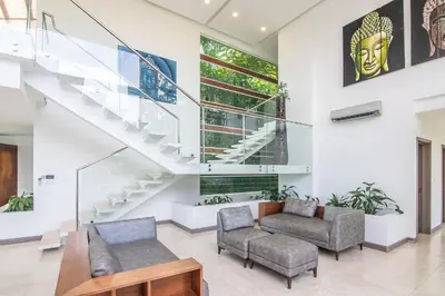 a living room with a staircase and two chairs at Luxury Villa #10 De Las Mariposas in Playa Hermosa