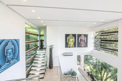 a staircase in a house with art on the walls at Luxury Villa #10 De Las Mariposas in Playa Hermosa