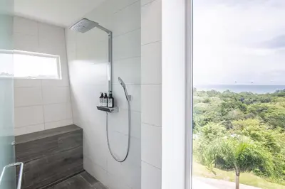 a bathroom with a shower with a view of the ocean at Luxury Villa #10 De Las Mariposas in Playa Hermosa