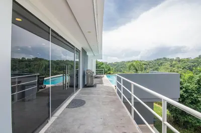 an outdoor balcony of a house with a swimming pool at Luxury Villa #10 De Las Mariposas in Playa Hermosa