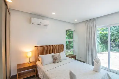 a bedroom with a bed and a large window at Luxury Villa #10 De Las Mariposas in Playa Hermosa