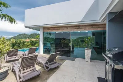 an outdoor patio with chairs and a grill at Luxury Villa #11 El Oceano in Playa Hermosa