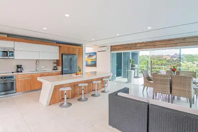 a kitchen with a counter and some chairs in it at Luxury Villa #11 El Oceano in Playa Hermosa