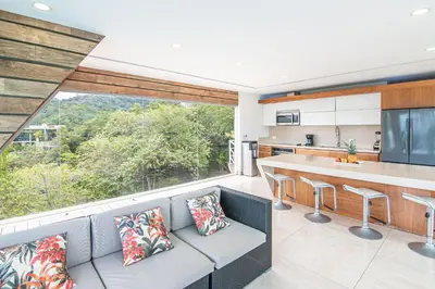 a kitchen and living room with a couch and a large window at Luxury Villa #11 El Oceano in Playa Hermosa