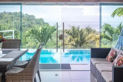 a living room with a view of a pool at Luxury Villa #11 El Oceano in Playa Hermosa