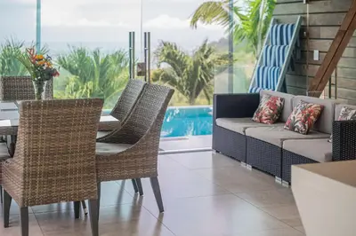 a patio with a table and chairs and a couch at Luxury Villa #11 El Oceano in Playa Hermosa
