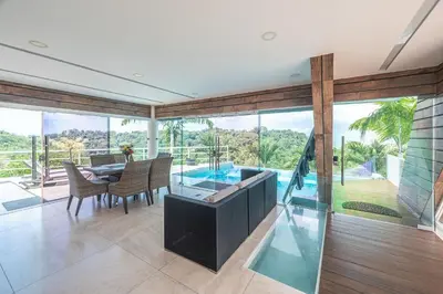 a dining room with a table and a pool at Luxury Villa #11 El Oceano in Playa Hermosa