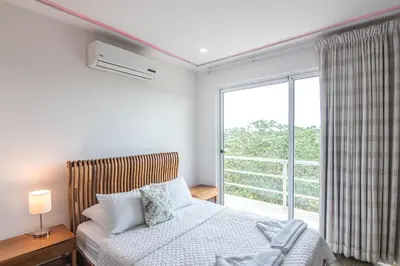 a bedroom with a bed and a large window at Luxury Villa #12 Las Flores in Playa Hermosa
