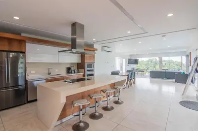 a kitchen with a large island with bar stools at Luxury Villa #12 Las Flores in Playa Hermosa