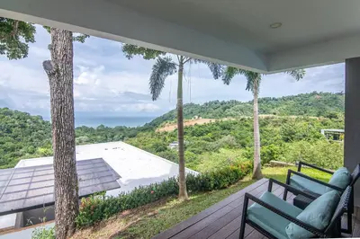 a house with a balcony with a view of the ocean at Luxury Villa #12 Las Flores in Playa Hermosa