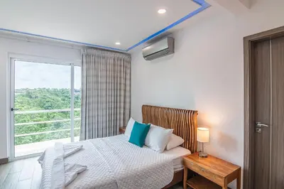 a bedroom with a bed and a large window at Luxury Villa #12 Las Flores in Playa Hermosa