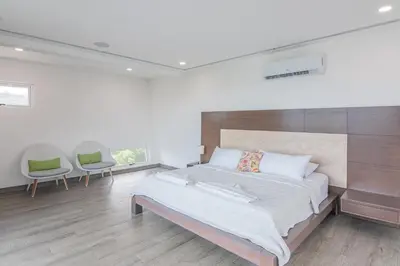 a bedroom with a large bed and two chairs at Luxury Villa #13 De Los Monos with Jacuzzi in Playa Hermosa