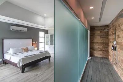 a bedroom with a bed and a glass wall at Luxury Villa #13 De Los Monos with Jacuzzi in Playa Hermosa