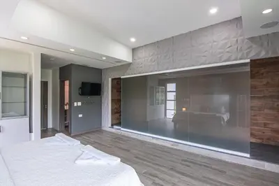 a bedroom with a bed and a large glass wall at Luxury Villa #13 De Los Monos with Jacuzzi in Playa Hermosa