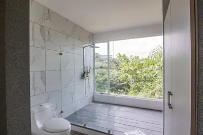 a bathroom with a toilet and a window at Luxury Villa #13 De Los Monos with Jacuzzi in Playa Hermosa