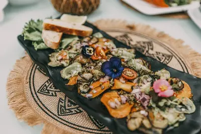 a plate of food with bread and vegetables on a table at Azul Hotel & Retreat in Playa Azul